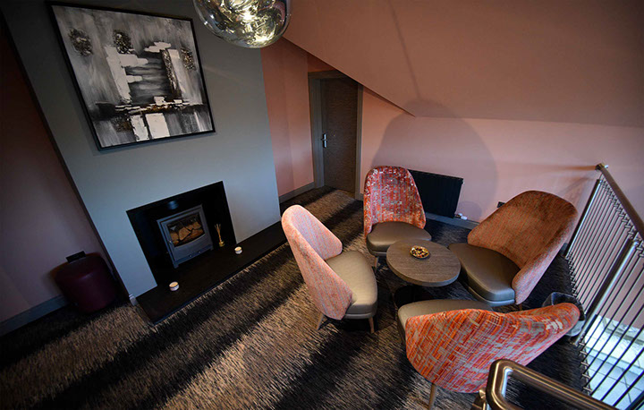 Relax in Taransay House Luxury Accommodation in Portree public seating area with woodburning stove